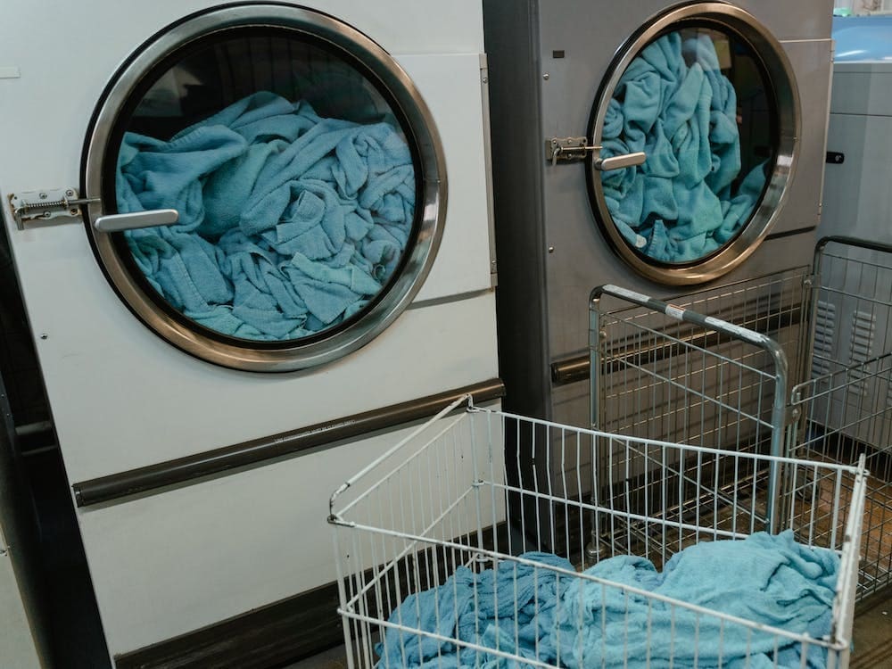 A laundry room with blue towels in a laundry basket.